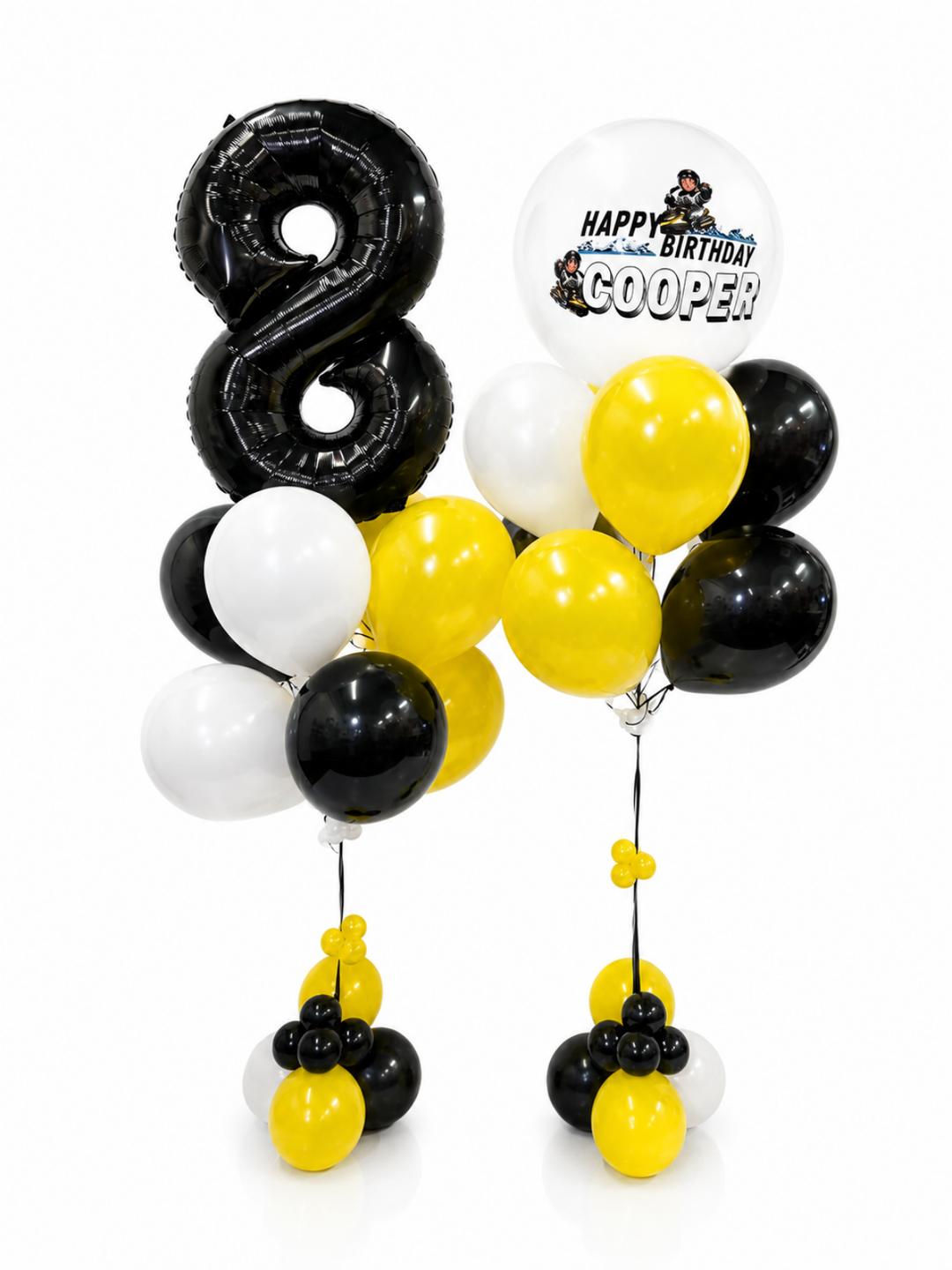 Black, white, and yellow balloon bouquet set for an 8th birthday, featuring a large black number 8 foil balloon, a round white balloon with 'HAPPY BIRTHDAY COOPER' text, and multiple coordinating balloons on two stands against a white background.