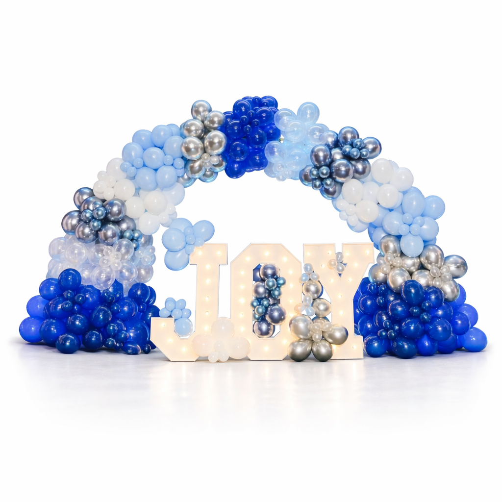 Balloon arch with blue, white, and silver balloons and the word 'JOY' in front.