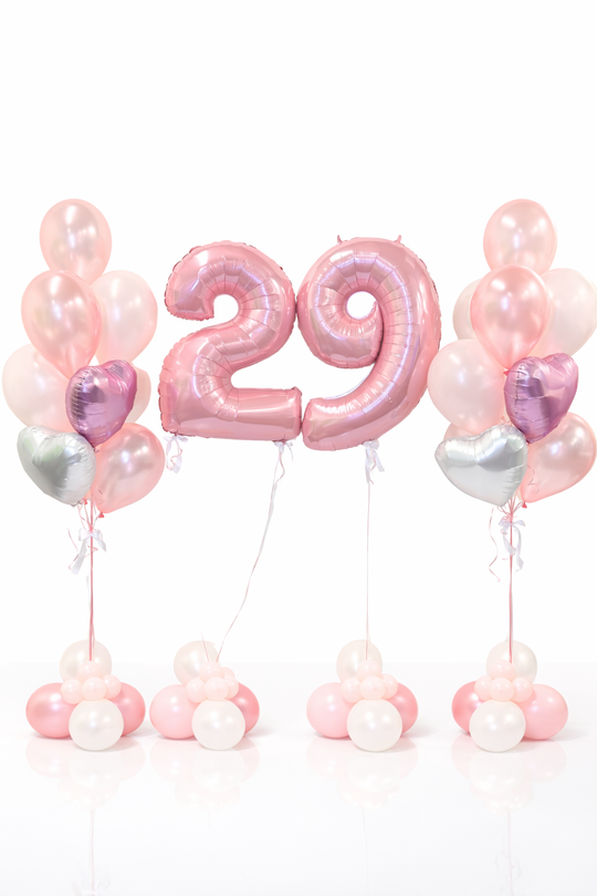 Pink number '29' balloon with pink, silver, and white balloons on a white background