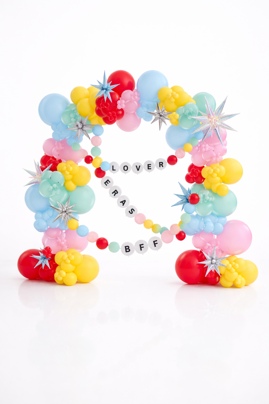 Colorful balloon arch with decorative elements on a white background
